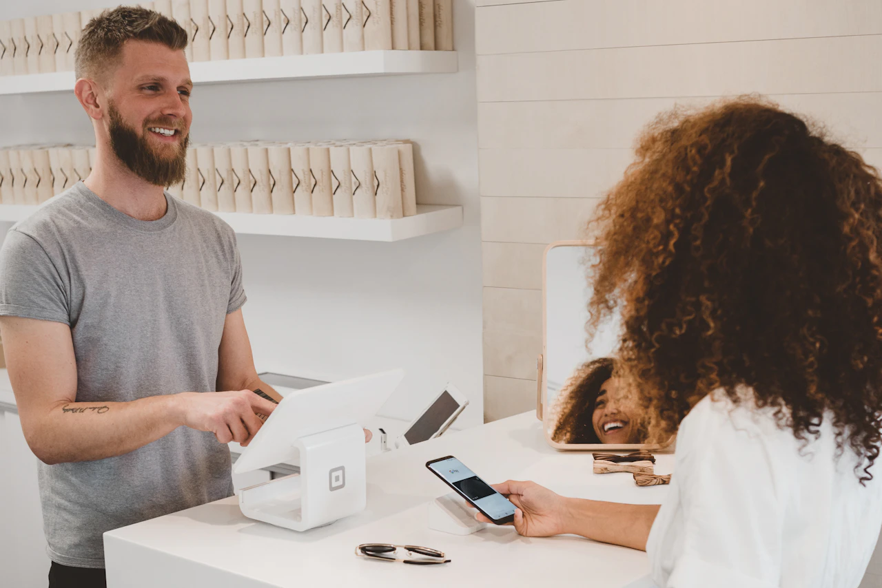 Retailer reviewing an online storefront on a laptop beside product samples